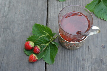 Berry strawberry tea and fresh garden strawberries on wooden background