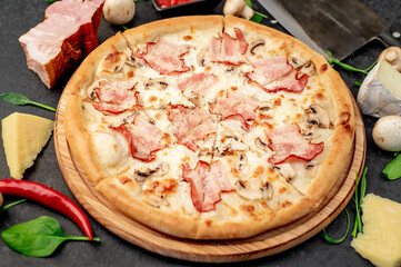 pizza with bacon, mushrooms and cheese on a stone background