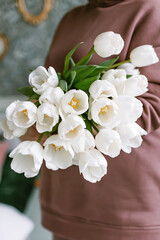 Large beautiful bouquet of tulips in the hands of a woman for the spring holiday