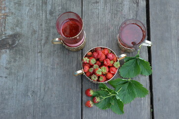 Berry strawberry tea and fresh garden strawberries on wooden background