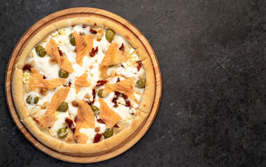 pizza with salmon, cheese and olives on a stone background  with copy space for your text