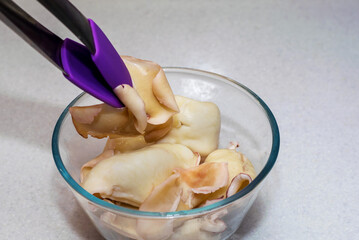Carcasses of boiled squid lie in a plate for further preparation of the delicacy.