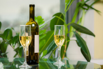 White wine bottle with two filled glasses