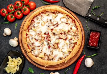 pizza with chicken, mushrooms and pineapple on a stone background