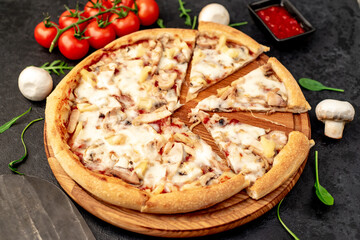 pizza with chicken, mushrooms and pineapple on a stone background