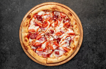 pizza with sausages, mushrooms, tomatoes and cheese on a stone background
