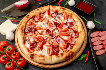 pizza with sausages, mushrooms, tomatoes and cheese on a stone background