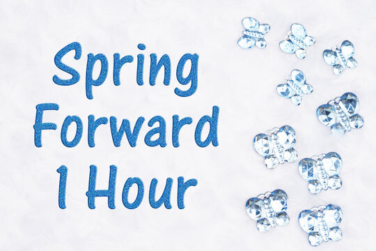 Spring forward 1 hour message with blue glass butterflies on white fabric