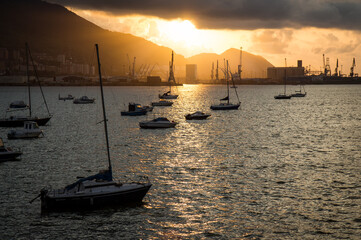 Bright sunset over the sea with sailboats at anchor in the harbor