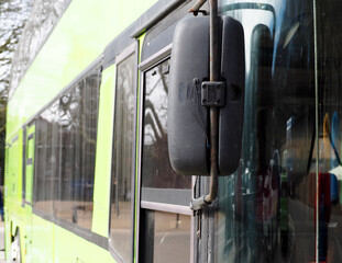 close outside rearview mirror of green double-decker sightseeing bus during the day
