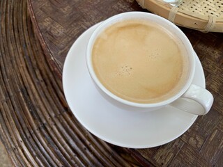 Hot americano with creama on white glass in a local setting