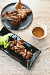 roasted pork neck and innards on plate dipping with tamarind sauce