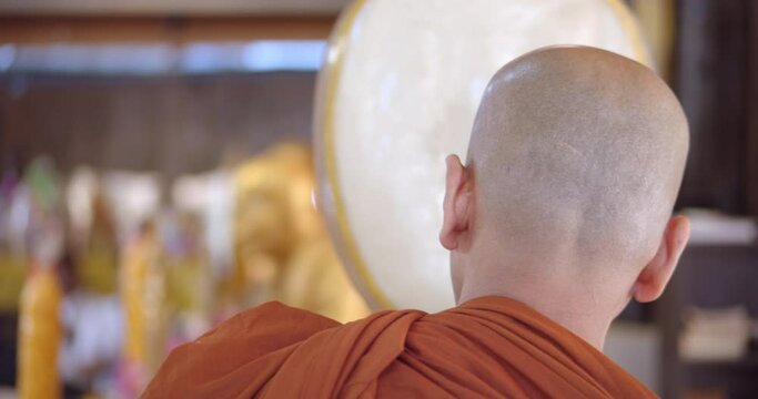 A Theravada Buddhist monk holds a talipot fan to preach and pray to the people who come to make merit at Buddhist ceremonies.
