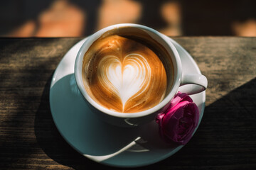 A Cup of hot latte art coffee on wooden table
