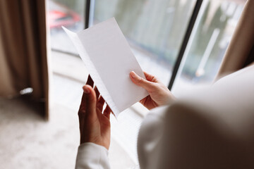 Wedding day. Fees at the hotel. the bride near the window and reads the letter to the groom. Wedding vows. Preparations. Morning of the bride. bride in white dress and veil. mock up space.