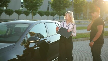 Striped shirt. Businessman buying a car. Professional vehicle female salesman is telling interested buyer stylish man about luxurious car. Woman manager talking insurer, consulting adult male customer