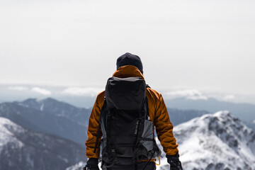 Fototapeta na wymiar 雪山登山で木曽駒ヶ岳山頂より３６０度のアルプス山脈の山並みを眺め感動する姿