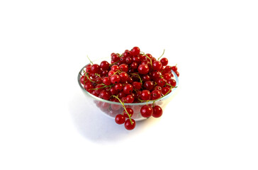 Isolated on white background red currant berries in a transparent plate