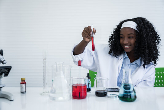 Happy African American Student Girl Is Learning And Test Science Chemical With Colorful Liquid In Tube Test And Beaker In Laboratory Room At To School.