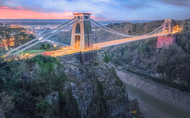 Cityscape view of Bristol, England, UK and the Clifton Suspension Bridge above the Avon Gorge and River Avon at sunset or sunrise from St Vincent's Rocks.
