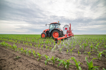 Tractor spraying pesticides at corn fields