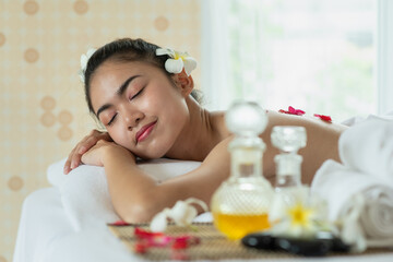 Obraz na płótnie Canvas Beautiful Asian woman lying down on massage bed relaxing in spa salon