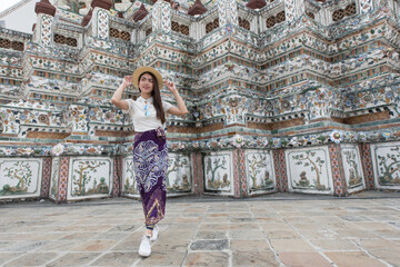 Fototapeta na wymiar Young Asian women tourist traveling at Wat Arun Ratchawararam, one of the famous places in Bangkok, Thailand