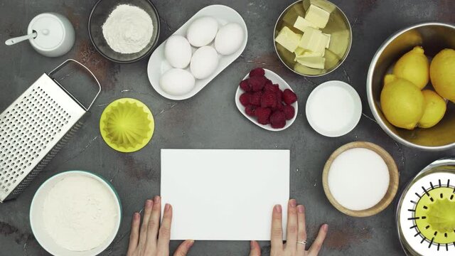 Lemon cake cooking ingredients and a blank notepad paper page, flat lay, top view
