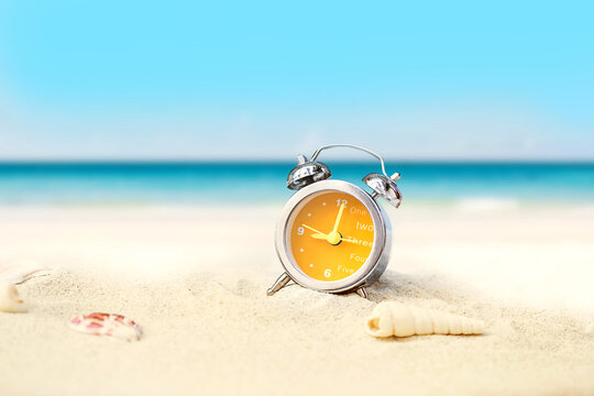 last minute to count down for travel or travel vacation concept. metaphor by old retro clock on sand beach.