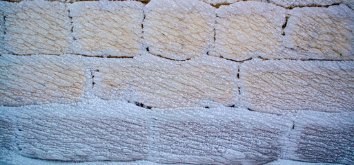 Brick wall in the snow, the wall of the house after the storm .
