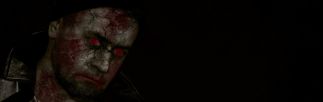 Horror scene of a man with bloody face. Banner of zombie close-up.. Toned image. Horror concept