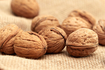 Close-up walnuts lie on a burlap.
