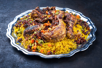 Traditional fried Arabic chicken majboos with chicken leg and jeweled rice served as close-up in a...