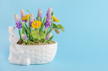 Easter card, composition with rabbit and flowers on a blue background with copy space