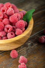 Fresh raspberry in wooden bowl. The berry is rich in vitamins.