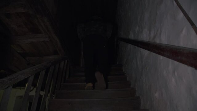 Hombre blanco cauc&aacute;sico camina hacia arriba. Escena nocturna de una casa antigua