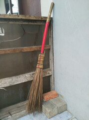 a broom that is placed on the wall outside the house