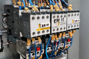 Close-up of magnet starters in electrical cabinet of automation control industrial system.