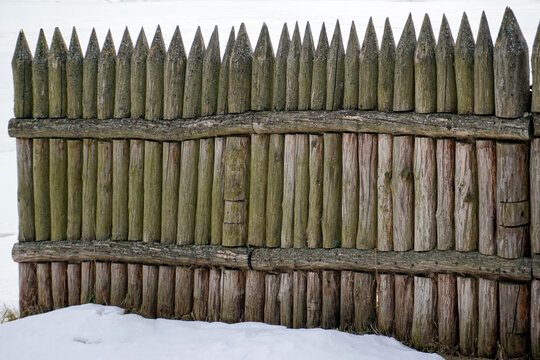 A hedge of sharpened sharp stakes. A fence made of wood. Fencing