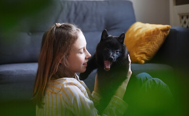 Obraz premium Tween girl playing with puppy at home.