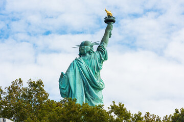 Statue of Liberty National Monument back view with blue sky background. New York, USA.
