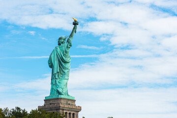 Statue of Liberty National Monument back view with blue sky background. New York, USA.