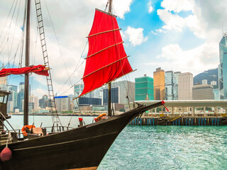  Traditional wooden sailboat or junk boat with red sails in the Victoria harbor, Hong Kong