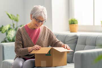 senior woman is holding cardboard box