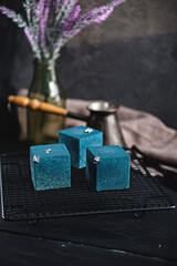 Blue cake filled with orange and tangerine in the shape of a cube. Rustic style.
