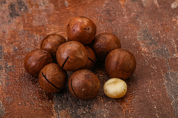 Brown macadamia nut heap over background