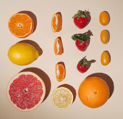 Creative layout made of fruits,flat lay,lemon,orange,tangerin,fortunella,strawberry,pink grapefruit on the pastel background
