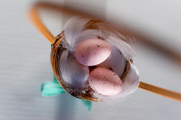 Jajka wielkanocne pastelowe w koszyku w otoczeniu piór , święta wielkanocne