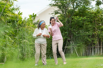 Fototapeta premium Smile young woman take care hug happy elder after running (cool down) in the morning exercise in the park.