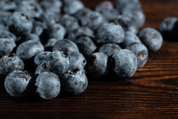 Blueberries in drops of water on a brown wooden table